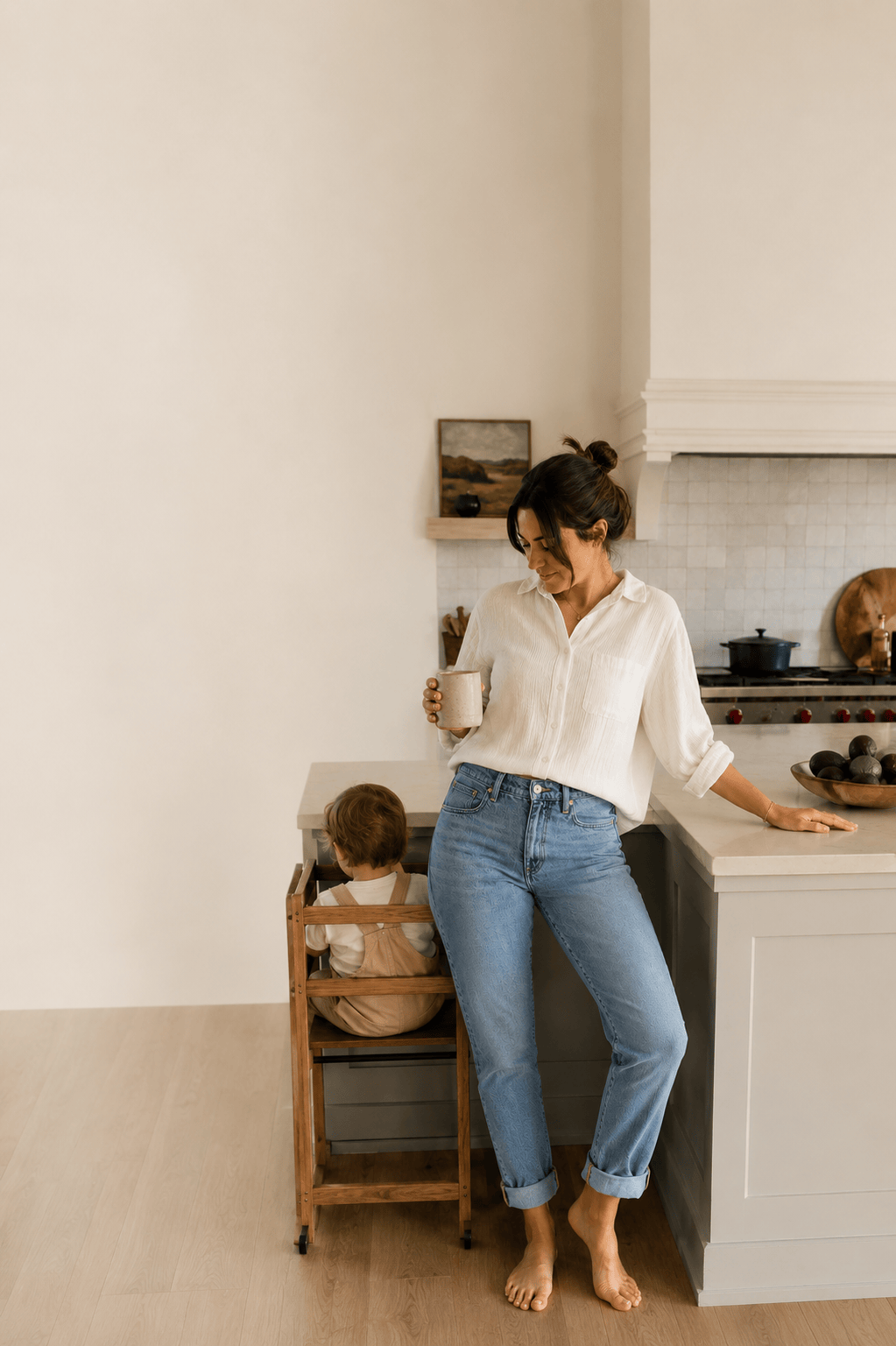 A woman at home wearing high-rise medium blue jeans with a relaxed waistband